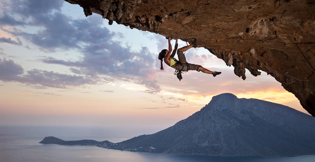 Woman rock climbing on a large rock overhang