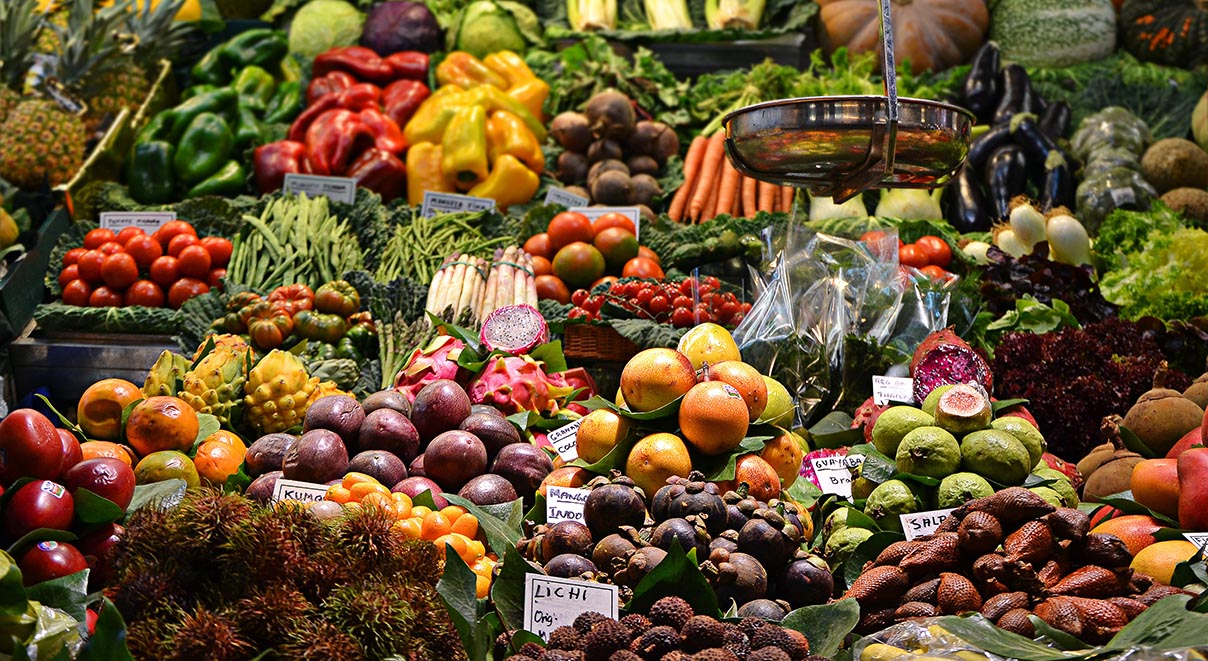 Different types of vegetables like peppers, onions, squash, pumpkin, tomatoes and more in an outdoor market